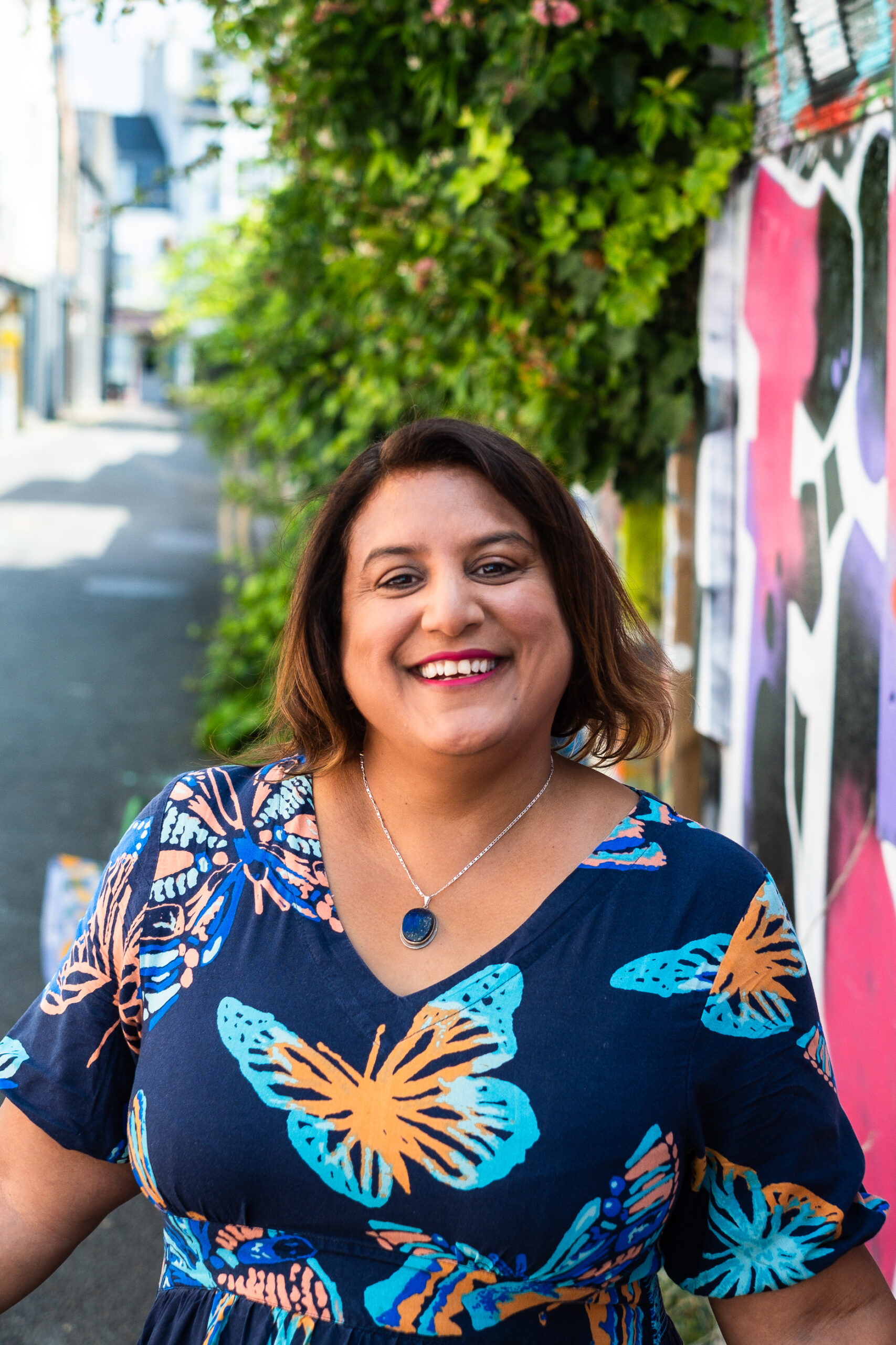 Mo smiling with patterned wall behind