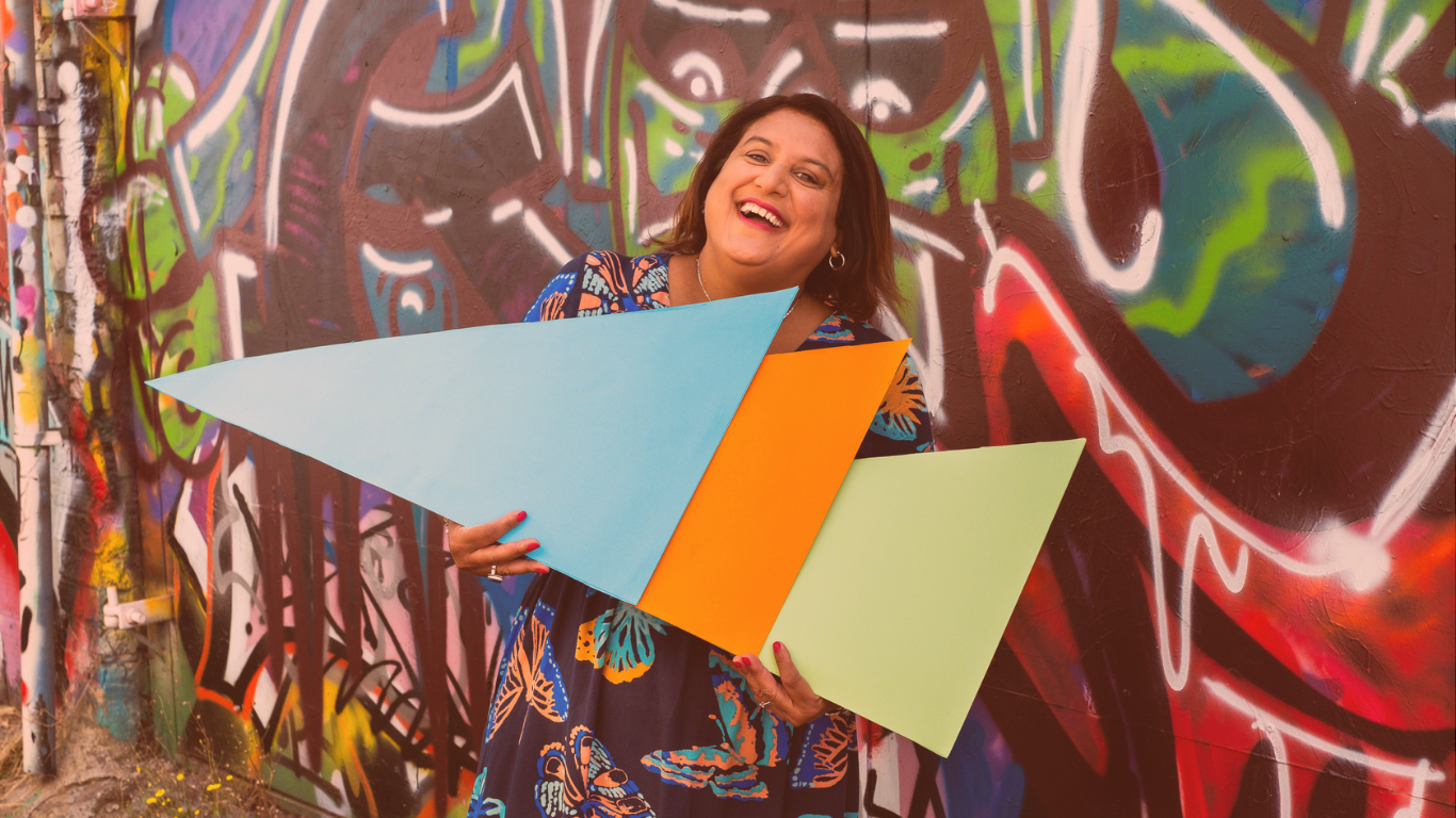 Mo with multicoloured background holding coloured triangle