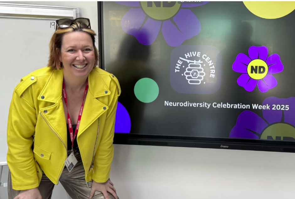 Untitled design Rose wearing yellow jacket standing in front of a screen