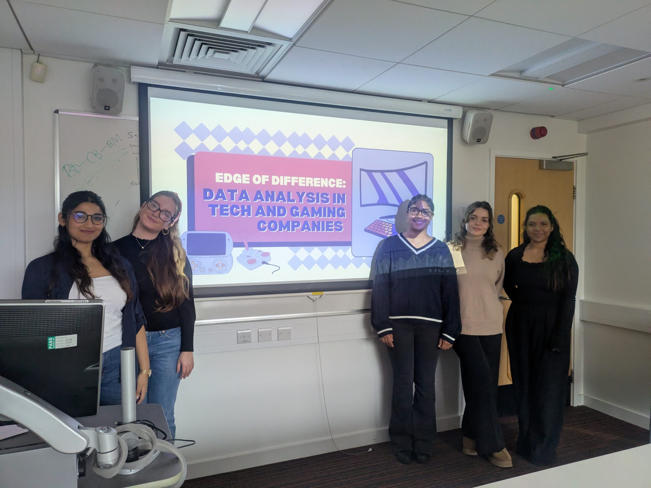 Group of female students standing in front of screen